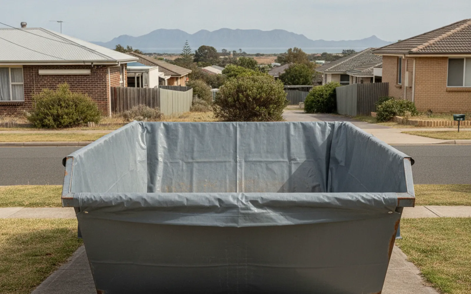 Skip bin lined with heavy plastic sheeting holding sealed wrapped bundles